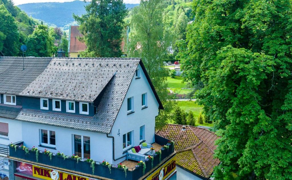 a white house with a gray roof and trees at Am Klosterviertel in Bad Herrenalb