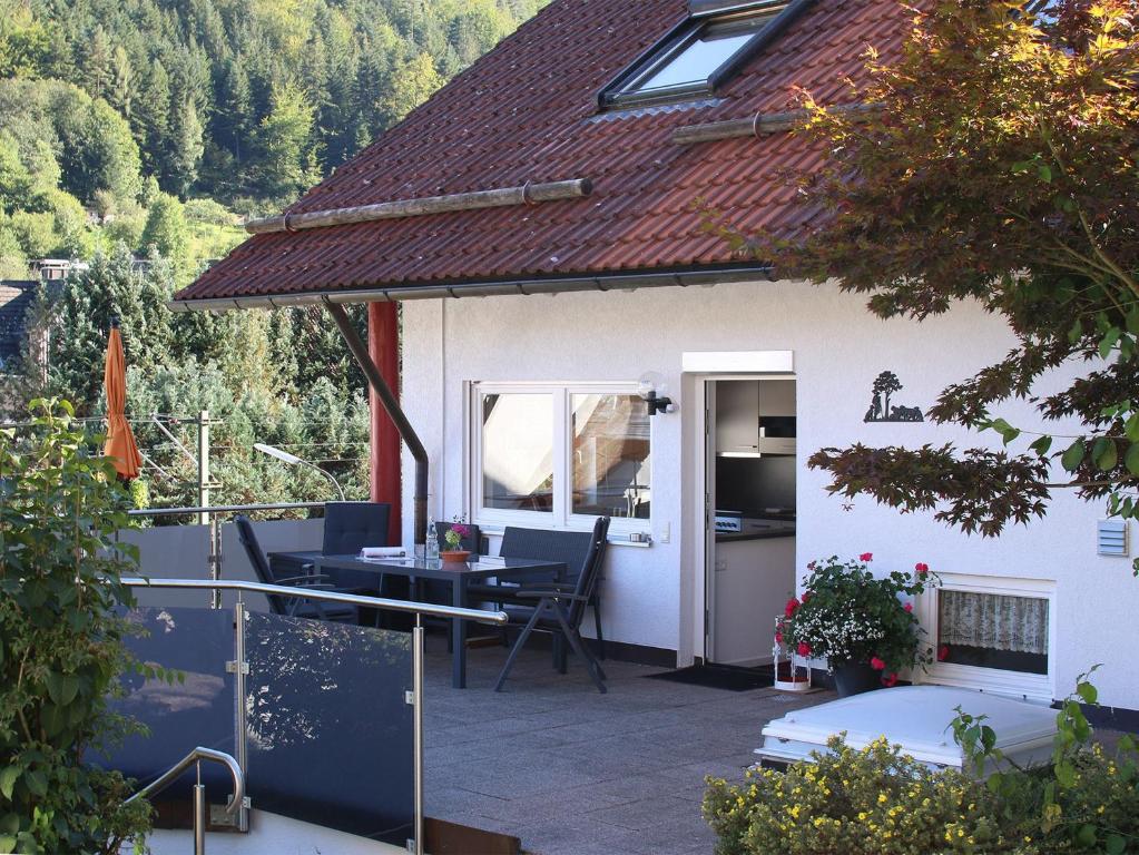 a house with a patio with a table and chairs at Ferienwohnung Am Eiberg in Bad Wildbad