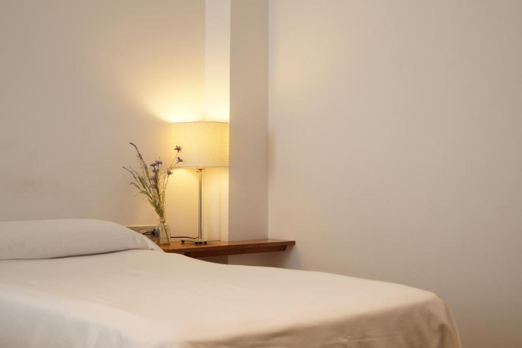 - une chambre avec un lit et une table avec une lampe dans l'établissement Hotel El Patiaz de la Reina Rana, à Tauste