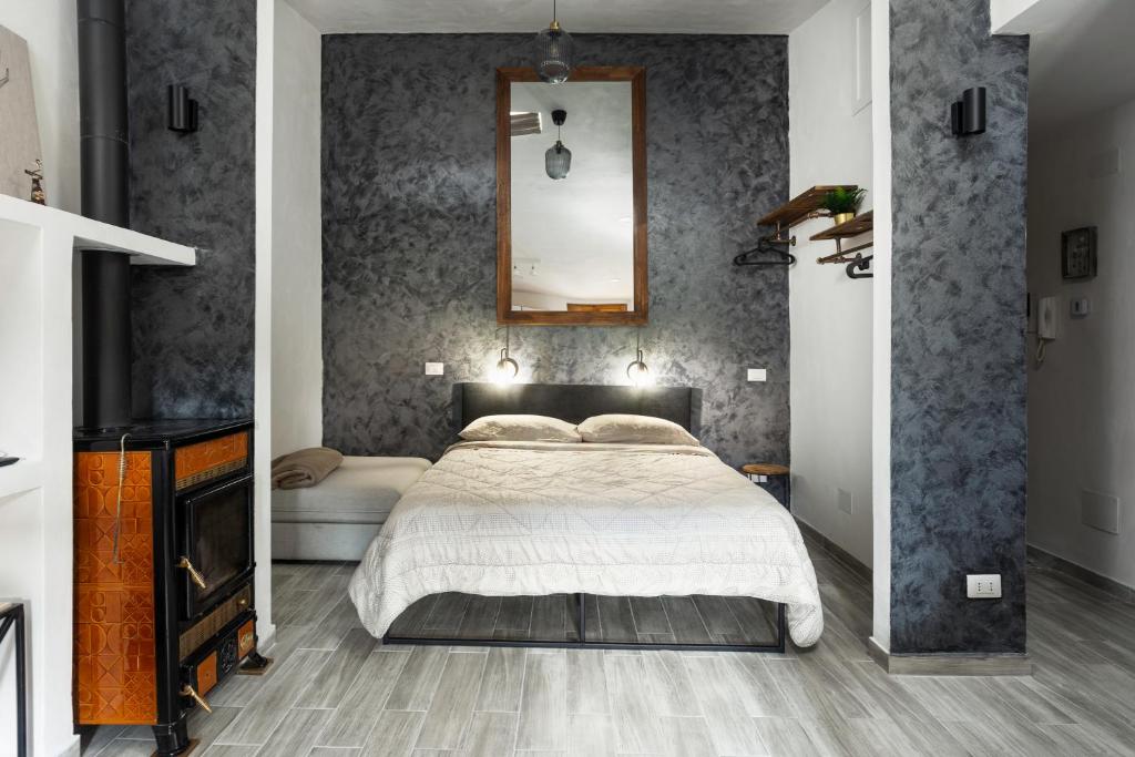 奧溫多利的住宿－Loft Deluxe Magnolia - Ovindoli，卧室配有一张床,墙上设有镜子