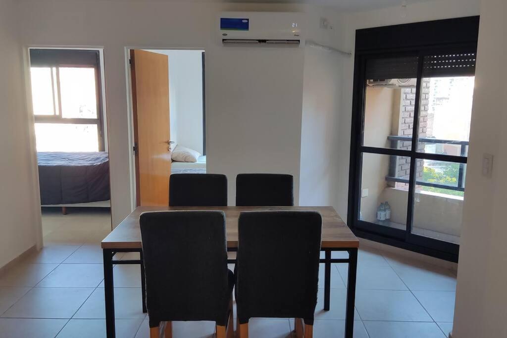 1 dormitorio y mesa de comedor con sillas. en departamento de dos dormitorios en Córdoba