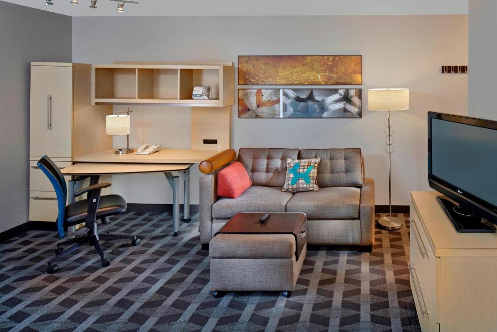 アルバニーにあるTownePlace Suites by Marriott Albany Downtown/Medical Centerのリビングルーム(ソファ、テーブル、デスク付)