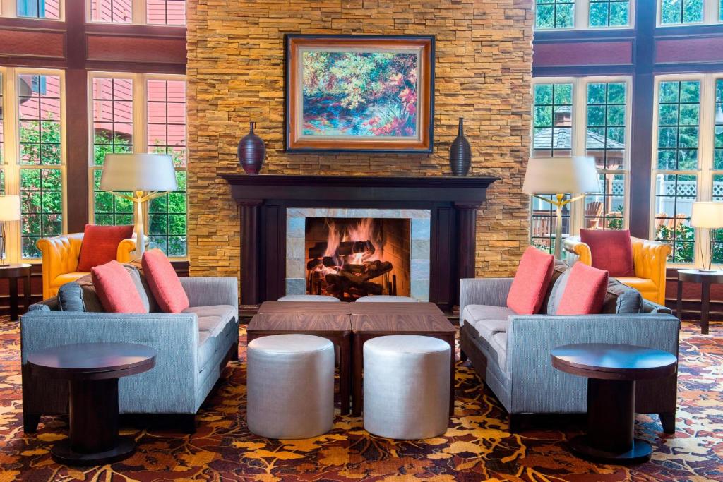 a living room with two couches and a fireplace at Courtyard Marriott Lake Placid in Lake Placid