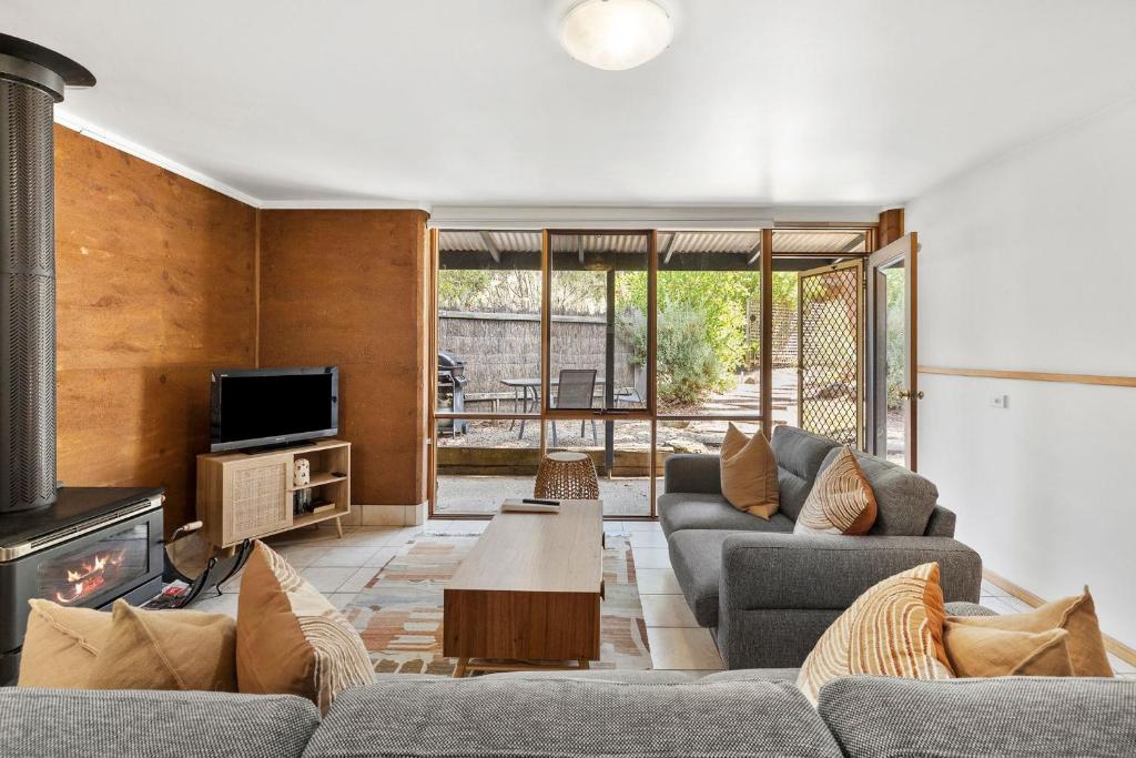 a living room with two couches and a fireplace at Split Point Cottages in Aireys Inlet