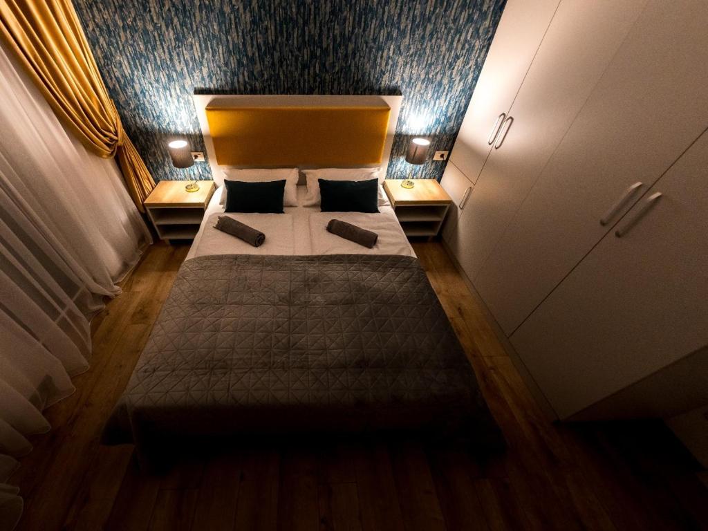 ein Schlafzimmer mit einem Bett mit zwei Kissen darauf in der Unterkunft Prime Apartments City Center in Suceava
