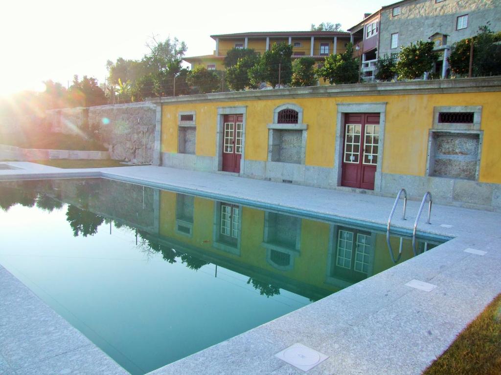 a pool of water in front of a building at Quinta do Rocha in Vilela