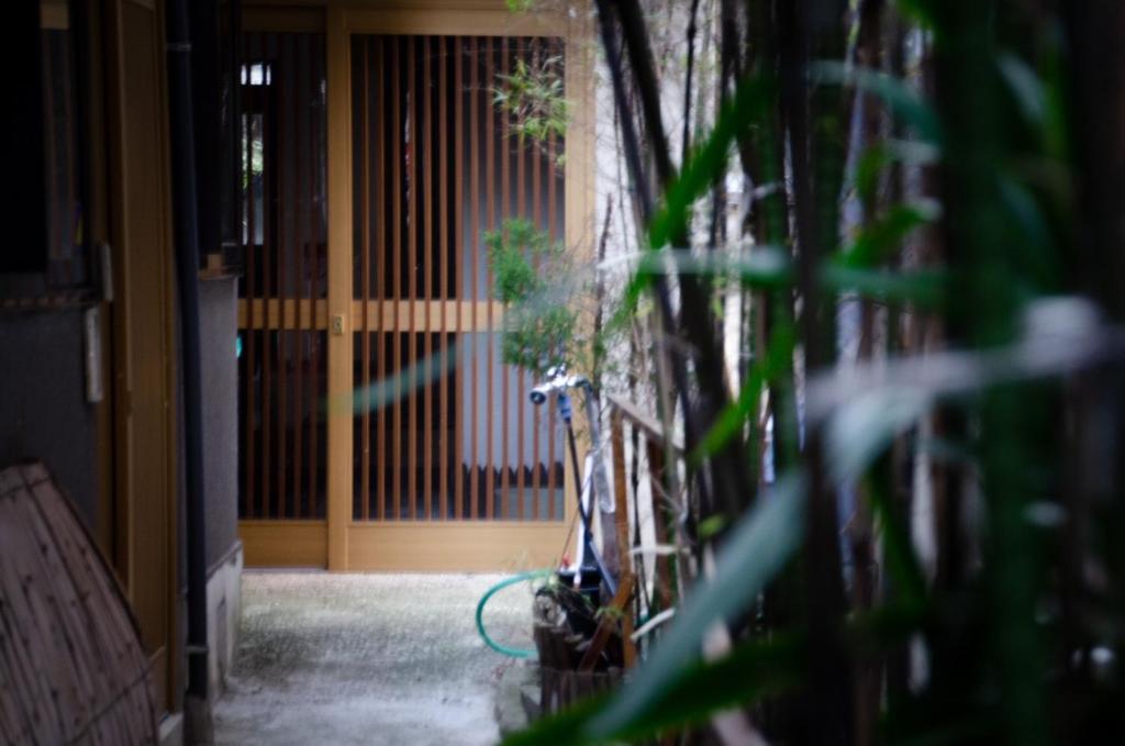 a bike parked in front of a door with a plant at Wafu Ryokan Uehonmachi in Osaka