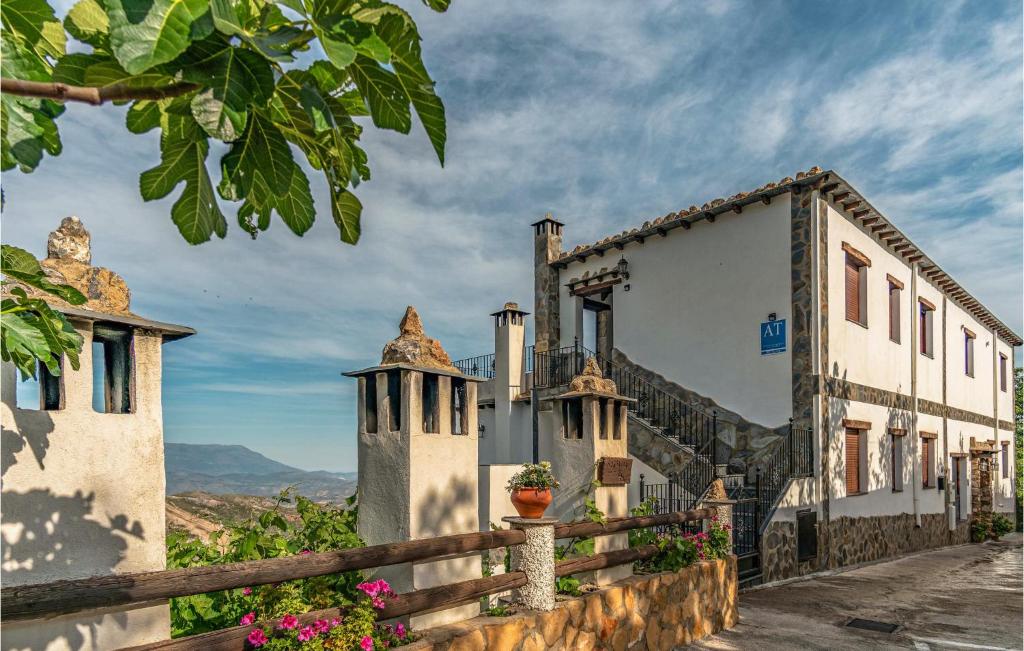 a row of white buildings with a fence and flowers at Amazing Home In Mecina Bombarn With Wifi in Mecina Bombarón