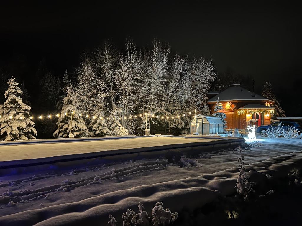 un cenador por la noche con nieve y luces en OR Luxury yurt-like home in Bretton Woods with private beach firepit AC fishing and trails, en Carroll