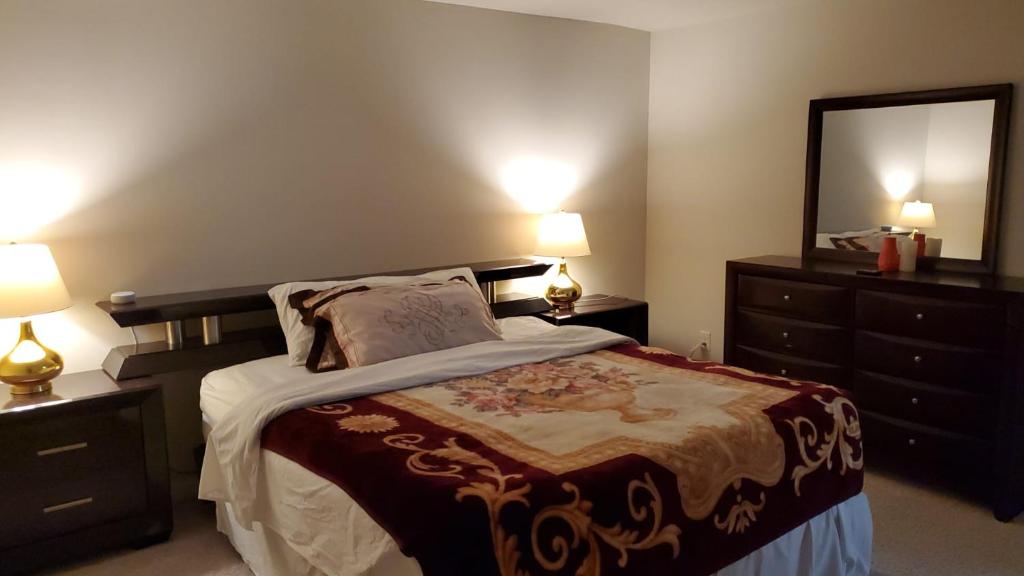 528 Carroll Walk Avenue في فريدريك: غرفة نوم بسرير مع مصباحين ومرآة
