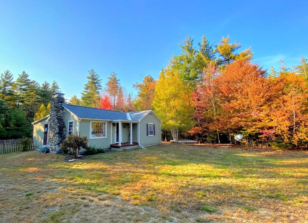 una pequeña casa blanca en medio de un patio en GC Adorable home 20 minutes from CannonFranconia Notch Fire Pit wifi laundry Pet friendly en Sugar Hill