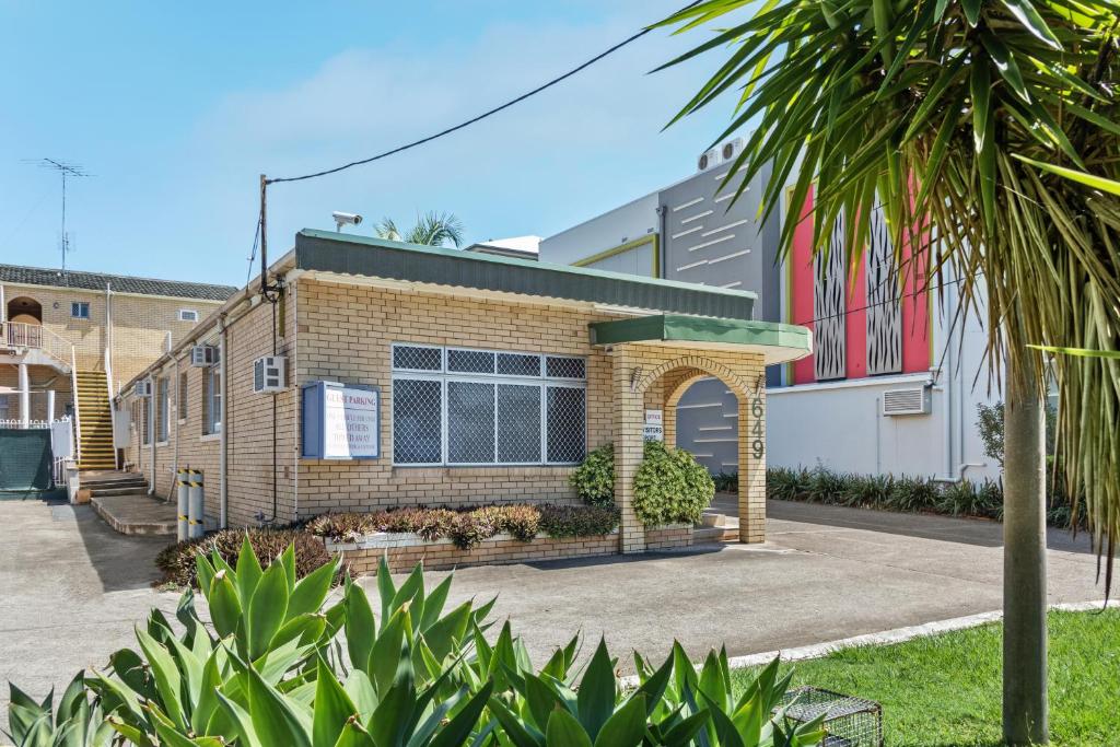 a brick building with a palm tree in front of it at Paramount Motel in Brisbane