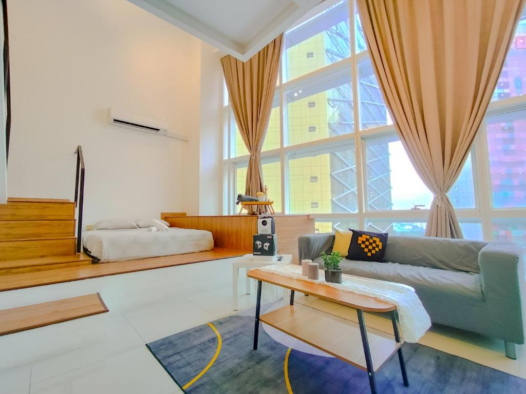 uma sala de estar com um sofá e uma mesa em Empire City PJ Signature Suites by Manhattan Group em Petaling Jaya