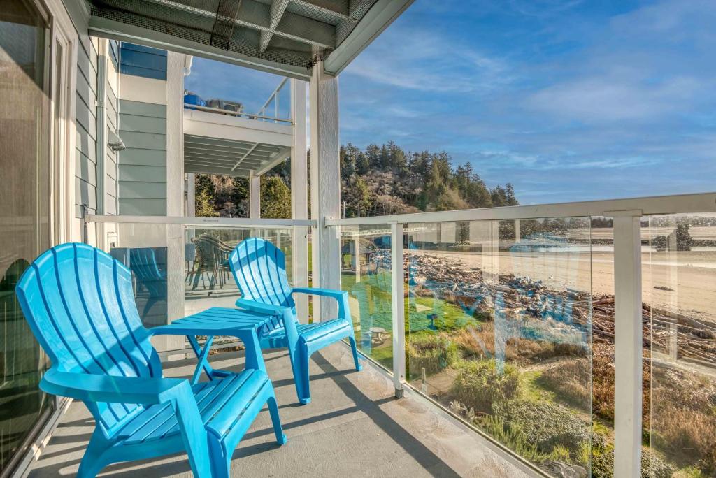 2 Stühle auf einer Veranda mit Blick auf den Strand in der Unterkunft Waters Edge 309 in Lincoln City