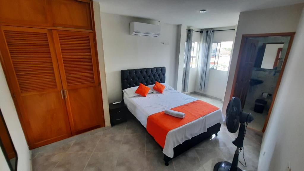 - une chambre dotée d'un lit avec des oreillers orange dans l'établissement Apartamentos en el Rodadero Sur- Ed San José, à Santa Marta