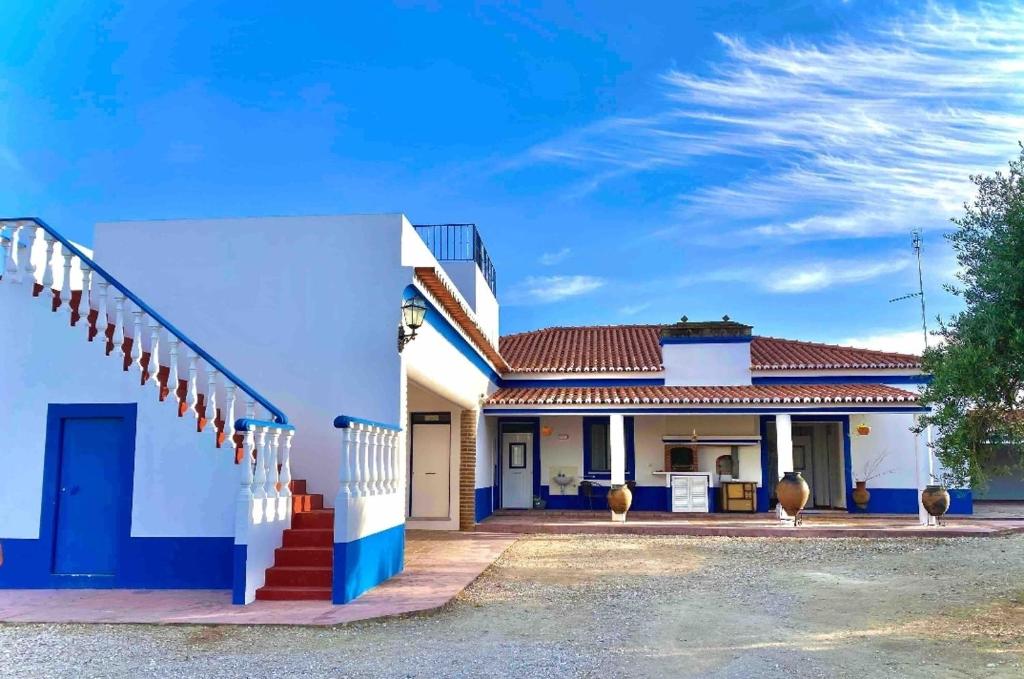 Casa blanca y azul con techo rojo en HERDADE DO CORVAL, en Reguengos de Monsaraz