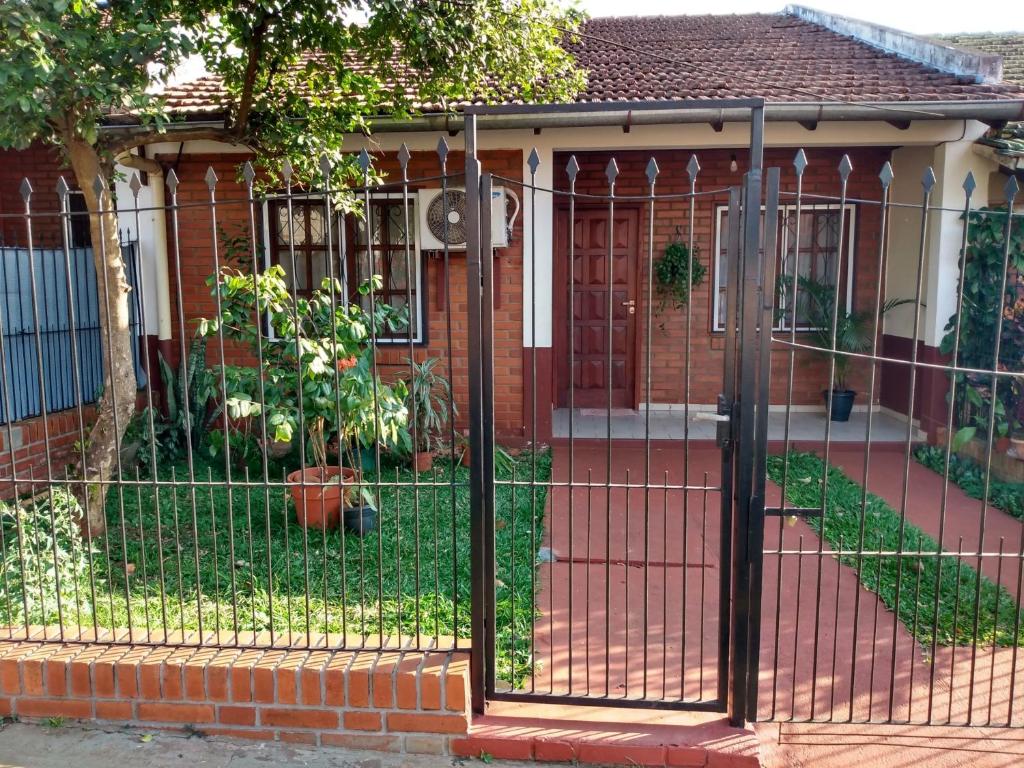 una cerca de metal frente a una casa en Alquiler Casa Iguazú en Puerto Iguazú