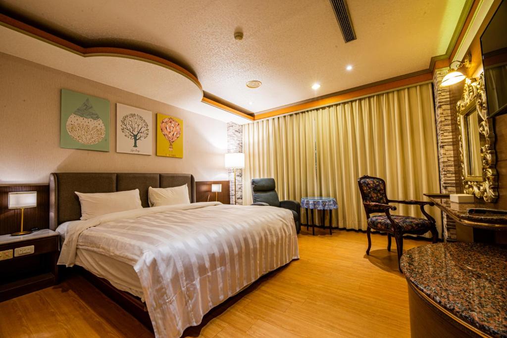 a hotel room with a bed and a desk and chair at Wenpin Hotel - Pier 2 in Kaohsiung