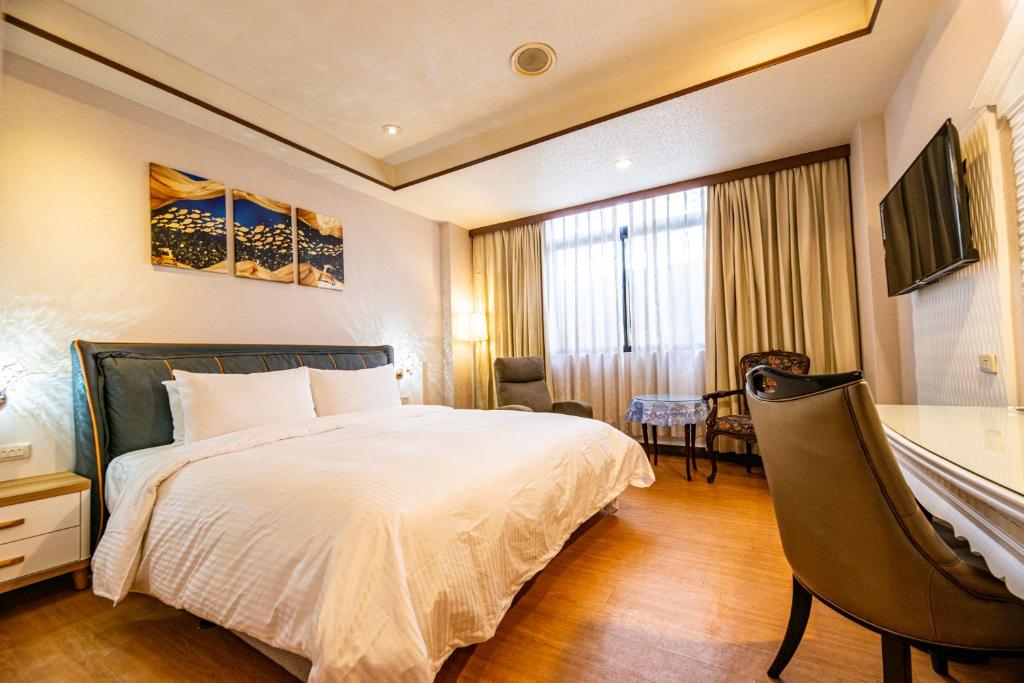 a hotel room with a bed and a desk at Wenpin Hotel - Pier 2 in Kaohsiung