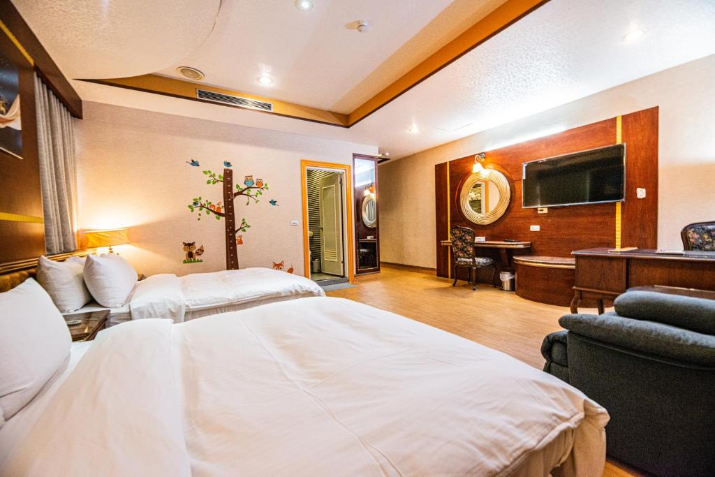 a hotel room with a bed and a television at Wenpin Hotel - Pier 2 in Kaohsiung