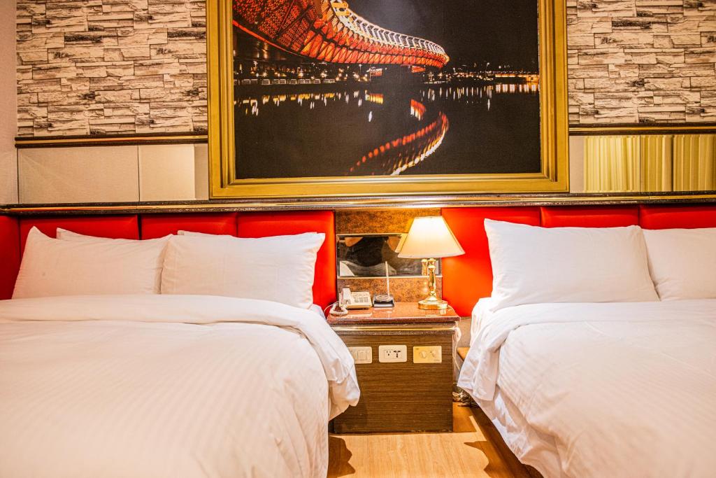 a hotel room with two beds and a painting on the wall at Wenpin Hotel - Pier 2 in Kaohsiung