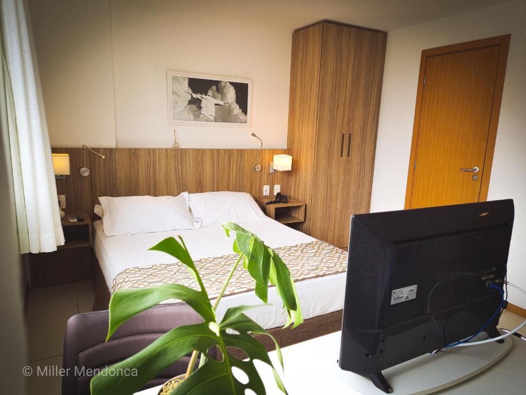 a hotel room with a bed and a television at Quarto Executivo para Sua Estadia de Trabalho in Campos dos Goytacazes