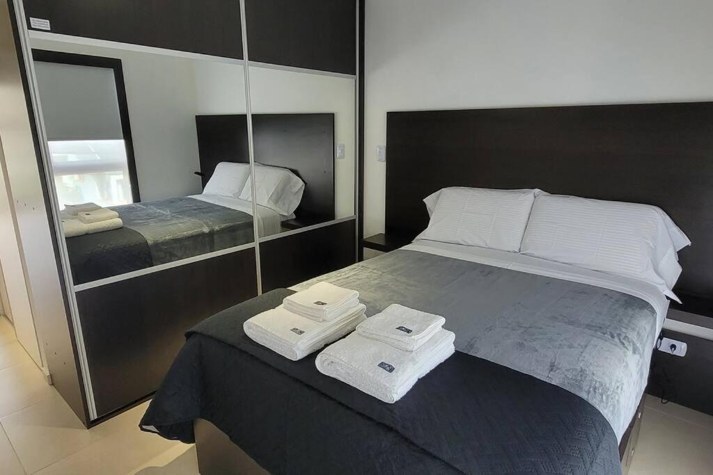 Comfortable apartment and excellent location في أوشوايا: غرفة نوم مع سرير وفوط مطوية عليه