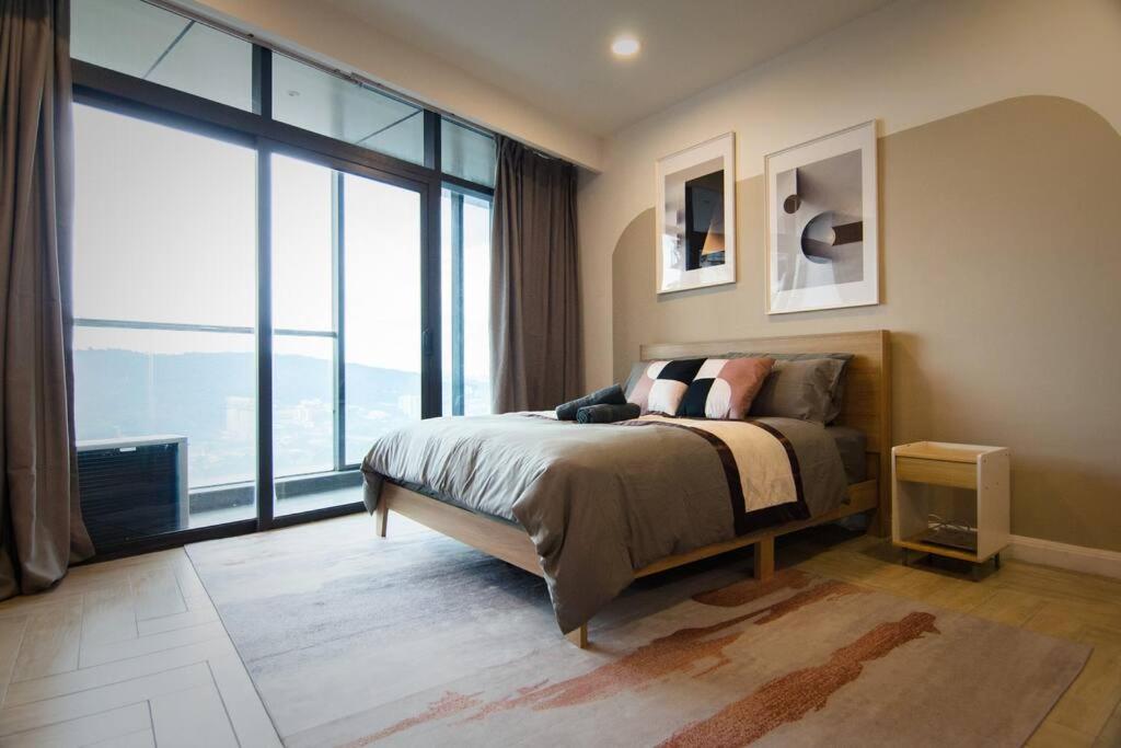 ein Schlafzimmer mit einem Bett und einem großen Fenster in der Unterkunft KL Exquisite Minimalist Balcony Suite Empire City Marriot in Petaling Jaya