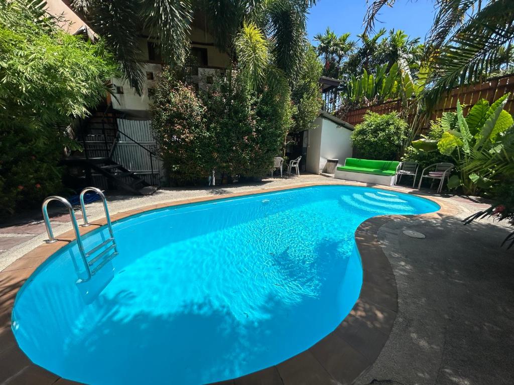 una piscina con acqua blu di fronte a una casa di Passion Nai Harn a Nai Harn Beach