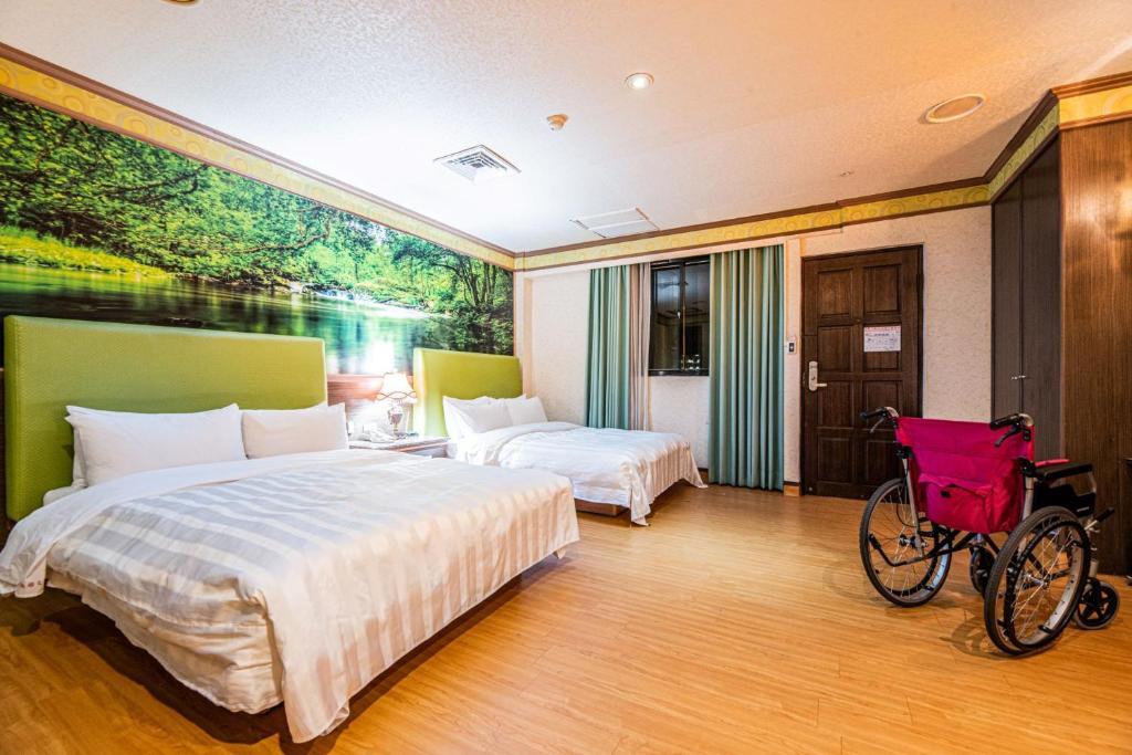 a bedroom with two beds and a bicycle in it at Wenpin Hotel - Pier 2 in Kaohsiung