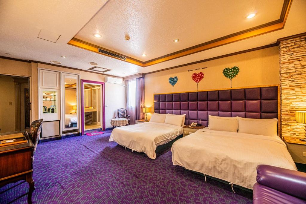 a hotel room with two beds and a piano at Wenpin Hotel - Pier 2 in Kaohsiung