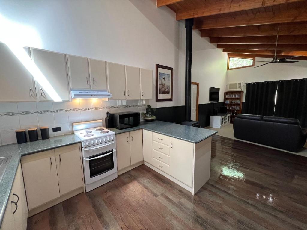 a kitchen with white cabinets and a stove top oven at The Kingfisher Lodge 111 in Halls Gap