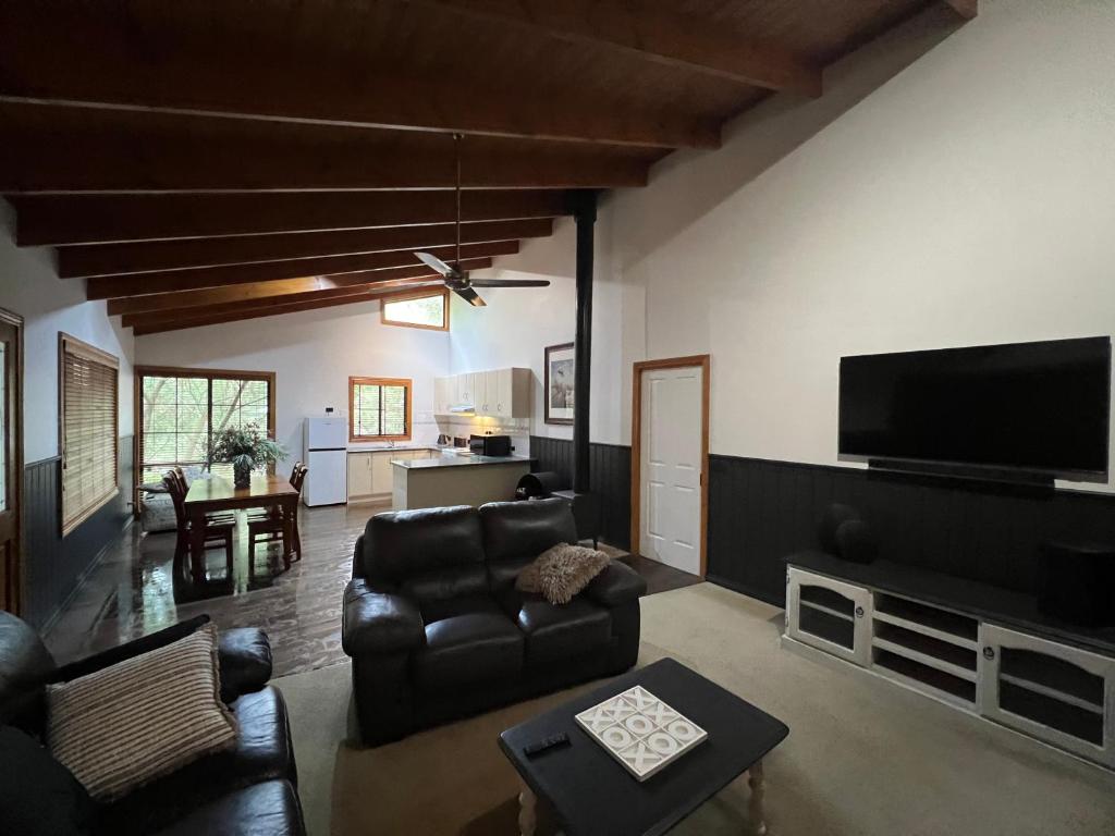 a living room with a couch and a flat screen tv at The Kingfisher Lodge 111 in Halls Gap
