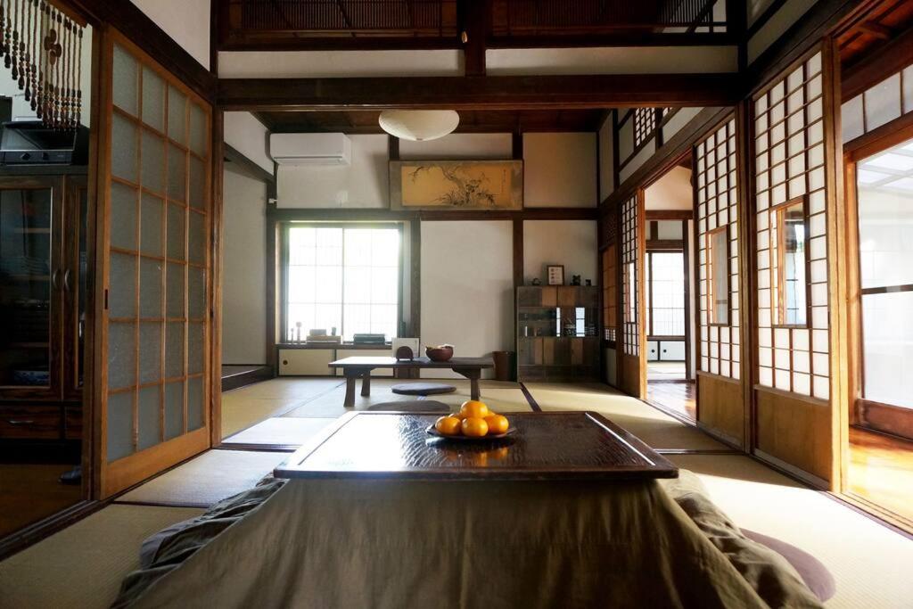 a living room with a table in a room with windows at 桜山ノウチ in Zushi