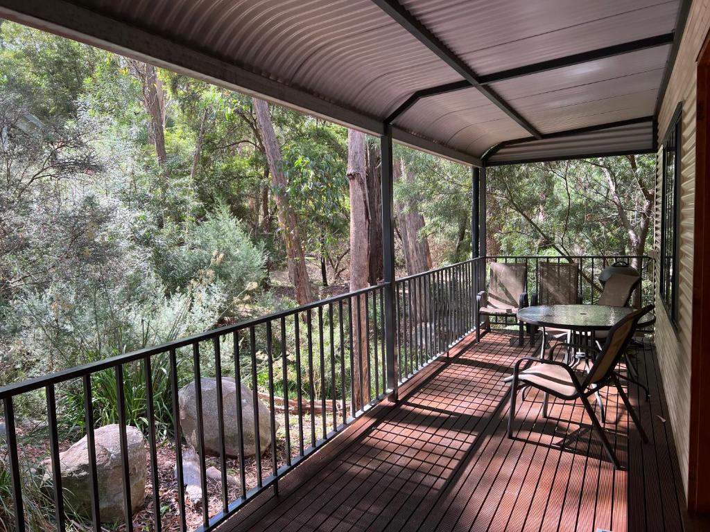a screened in porch with a table and chairs at The Kingfisher Lodge 111 in Halls Gap