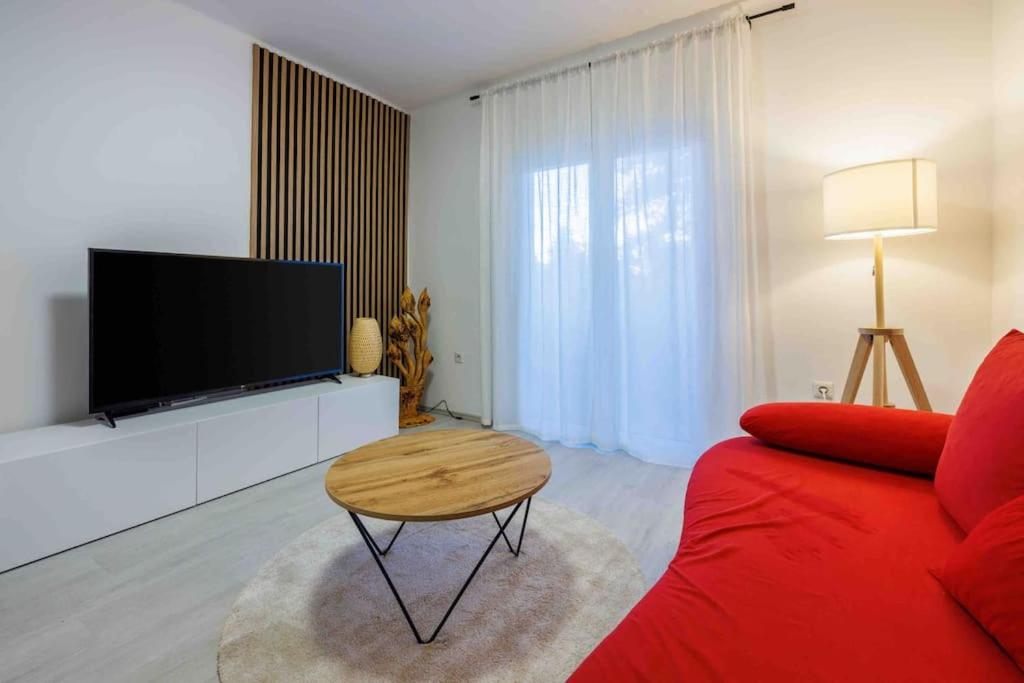 a living room with a red couch and a flat screen tv at Luxe City in Rijeka