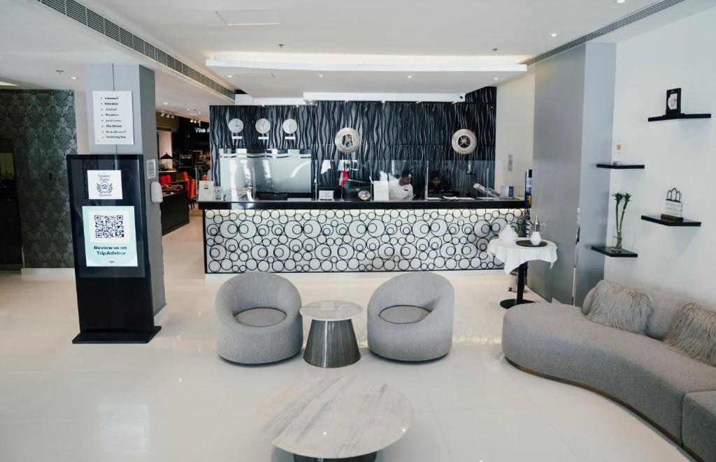 Best Western Premier Muscat في مسقط: غرفة معيشة مع أريكة وكراسي ومكتب