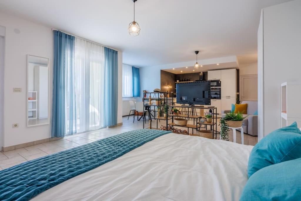 a bedroom with a large bed and a living room at Luxe Blue in Šmrika