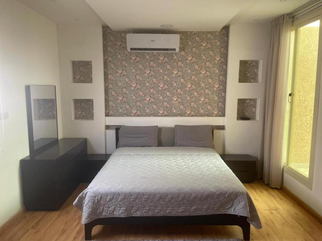 1 dormitorio con cama y pared en سفانه en Unayzah