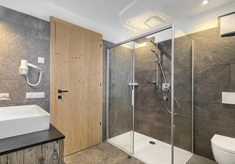 łazienka z prysznicem, toaletą i umywalką w obiekcie Apartment Pichlerhof w mieście San Lorenzo di Sebato