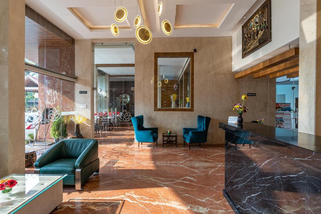 a lobby of a hotel with blue chairs at Le Seasons Resort in Candolim