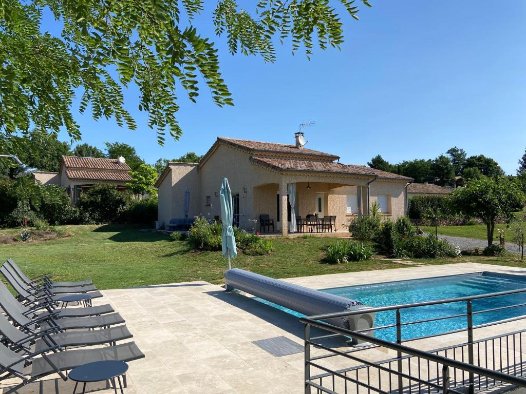 une villa avec une piscine, des chaises et une maison dans l'établissement La Grand Vigne - Maison avec piscine privée, à Saint-Genest-de-Bauzon