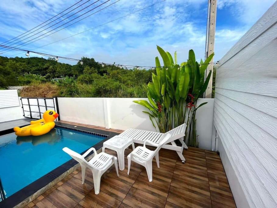a patio with a table and chairs and a pool at Pool Villa Sattahip White House in Sattahip