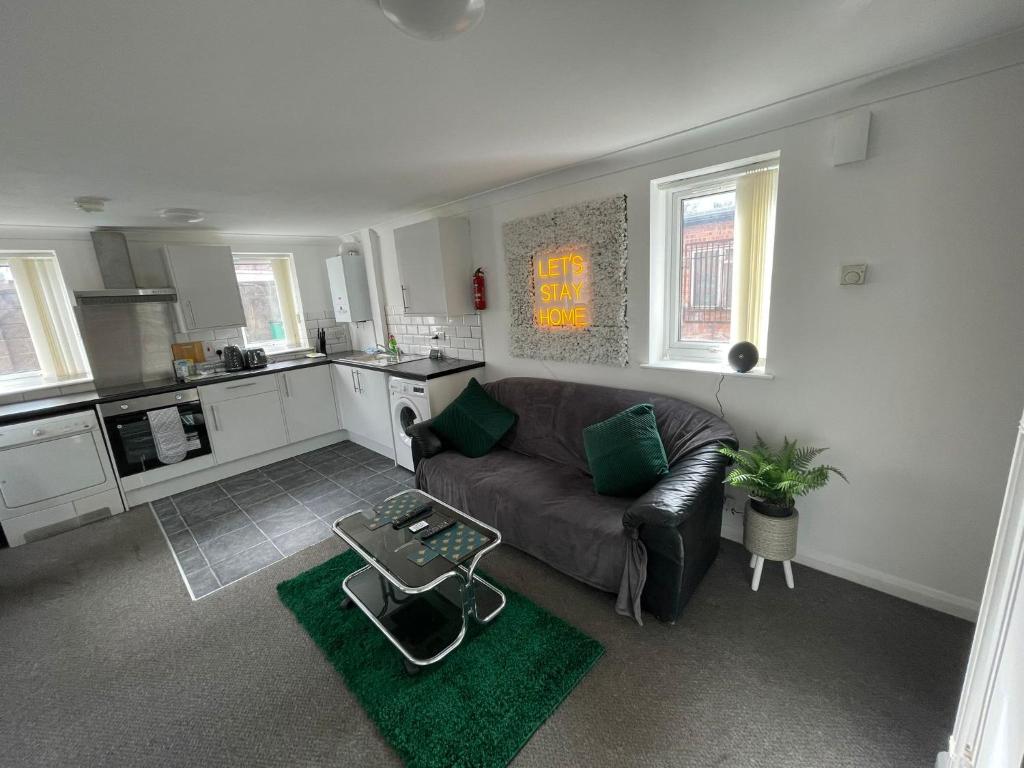 a living room with a couch and a kitchen at 1 Bed @ Factory Quater - Chard St in Nottingham