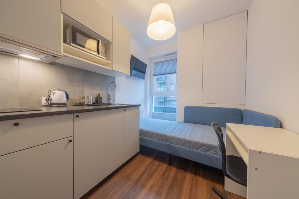 eine Küche mit einem Sofa und einem Bett in einem Zimmer in der Unterkunft TinyRooms in Kattowitz