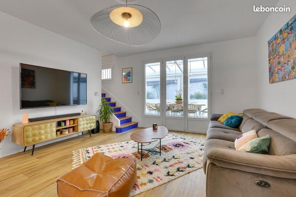 un salon avec un canapé et une télévision dans l'établissement VILLA LUNA - 9 couchages - terrain pétanque - wifi - netflix, à Capbreton