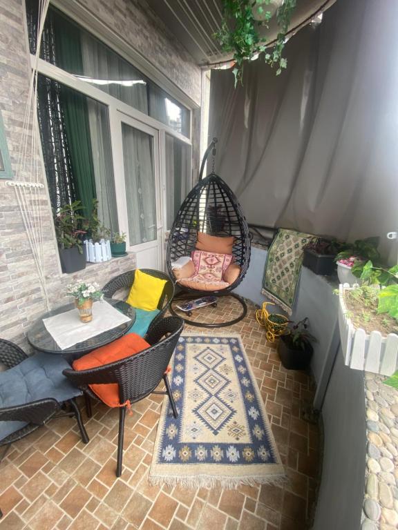 un patio con columpio, mesa y sillas en Dea Apartments, en Batumi