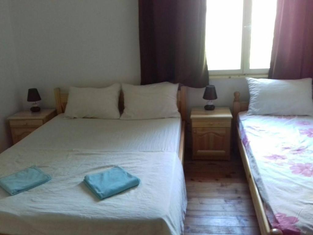 - 2 lits dans une chambre avec 2 serviettes bleues dans l'établissement Къща за гости Марчела и ресторант, 