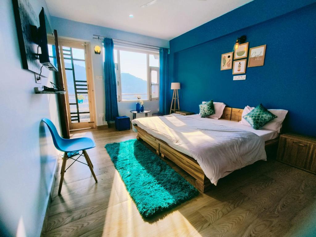 a blue bedroom with a bed and a blue wall at Blue Hills- B&B McleodGanj in Dharamshala