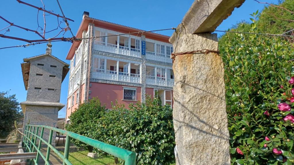 - un grand bâtiment avec un balcon et des fleurs dans l'établissement Hostal Boavista, à Costoia